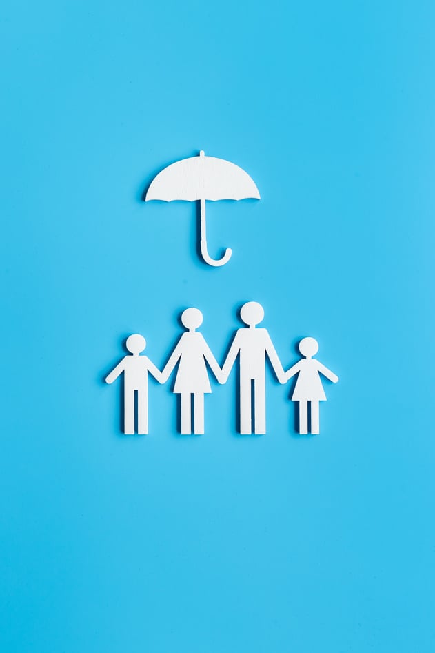 Wooden family figure under umbrella with space for text. Insurance concept